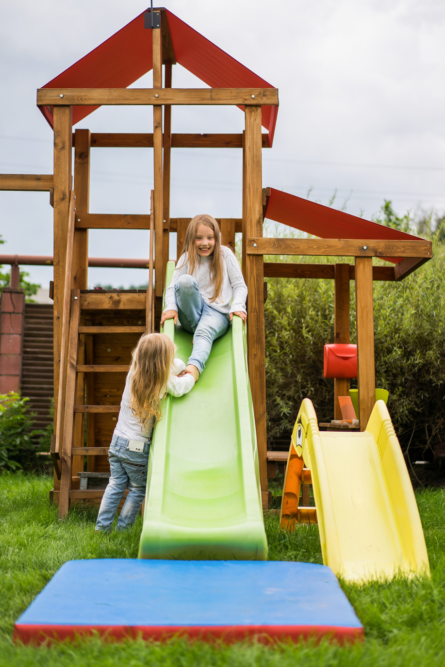 3_freepik_children-ride-from-children-s-slide-sisters-play-together-garden.jpg